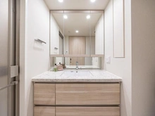 【東京都/世田谷区用賀】パークホームズ用賀三丁目 洗面所：人造石カウンターフィオレストーン。
上下オレフィン框付下部照明スペース付三面鏡。