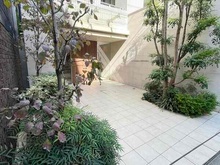 【東京都/港区南青山】オープンレジデンシア南青山骨董通り 骨董通りに面したエントランス。植栽の緑が映える洗練されたデザインで、スタイリッシュな印象です。
