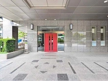 【神奈川県/横浜市中区山下町】グローリオタワー横浜元町 グレーを基調とした外壁に赤い扉が印象的なエントランス。庇があり、悪天候時も落ち着いて外出できます。